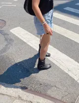 Bota corta de cuero color marrón, con taco de madera y punta cuadrada. Presenta una correa con hebilla alrededor del tobillo.