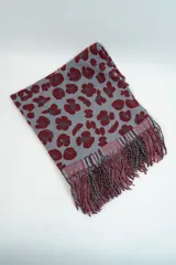 Chalina rectangular con estampado animal print en tonos beige y negro, terminada en flecos. Ideal para usar como bufanda o chal.
