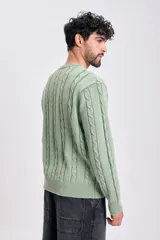 Sweater de tejido de punto color verde claro, con cuello redondo y diseño de ochos verticales en todo el cuerpo y mangas.