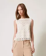 Top sin mangas de encaje color crema, con cuello redondo y detalle de lazos en los laterales.