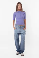 Top camiseta de morley color lila, con mangas cortas y calce slim. Cuello redondo cerrado con cartera de botones snap metálicos en delantero.
