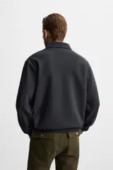 Polo manga larga gris con cuello solapa y cierre frontal de botonadura.
