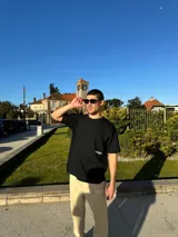 Remera negra de corte semi oversize con estampado en la espalda que dice "BIENA VIBRA feel the vibes" y un logo pequeño en el frente.