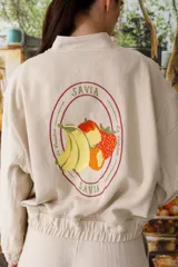 Bomber color coral confeccionada en mezcla de algodón y lino, con cierre frontal y puños elásticos. Presenta un bordado grande en la espalda inspirado en la colección La Verdulería.