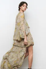 Vestido largo de viscosa con estampado floral, escote en pico, manga tipo capa con aberturas y bajo asimétrico.