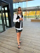 Chaleco de cuero marrón con detalle de tachas en el contorno.