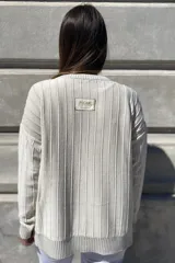 Sweater negro de tejido de punto con escote en V y rayas verticales plateadas.