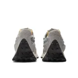 Championes urbanos New Balance modelo 327, color gris con detalles en azul, confeccionados en gamuza y nylon, con logo "N" característico en los laterales y entresuela de goma.