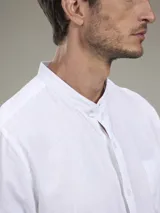 Camisa blanca de lino con cuello mao, manga larga con puños abotonados y bolsillo en el pecho.