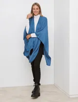 Ruana de tejido suave color morado oscuro, con cuello redondo y corte amplio tipo capa.