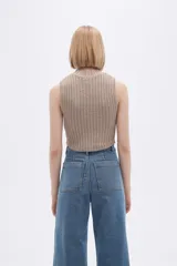 Chaleco verde pálido de punto con cuello alto y diseño trenzado.