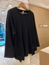 Buzo de lanilla con lurex color negro, de corte holgado y mangas largas. Presenta volados en los laterales inferiores.