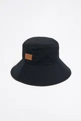 Gorro tipo bucket negro de tejido gabardina con etiqueta de piel logotipada.