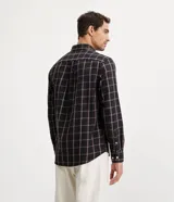 Camisa de franela a cuadros color negro, con botones blancos y corte clásico.