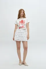 Falda corta blanca con volados de encaje y cintura elastizada.