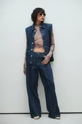 Pantalón de jean azul oscuro de pierna ancha con costuras marcadas al frente, tiro medio y calce relajado.