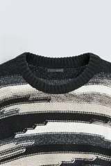 Sweater de punto con cuello redondo y manga larga, con diseño de rayas horizontales en tonos negro, gris y blanco.