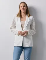 Blazer entallado blanco, marca Robert Louis. Cuello con solapa y abertura central con botón. Delantera con bolsillos. Manga larga calada.