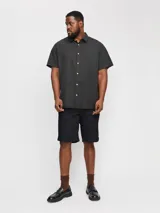 Short chino negro de lino y algodón, corte relajado, cintura media con elástico y cordón ajustable, bolsillos frontales y traseros.