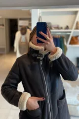 Campera marrón de cuero ovino con cuello y puños de piel sintética color crema, cierre frontal con cremallera y bolsillos laterales.