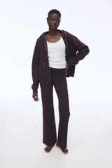 Campera con capucha color borgoña, con cierre frontal y bolsillos tipo canguro. Confeccionada en felpa con interior cepillado suave, hombros caídos, capucha forrada con cordón para ajustar y puños y bajo en punto acanalado.