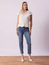 Blusa de dos piezas color blanco, marca Cupio. La pieza superior es de tul bordado con escote en V con botones, manga corta amplia y ruedo con puntilla bordada. Incluye forro interno a tono.