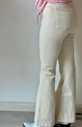 Pantalón de jean color crudo, de corte semioxford con aberturas en el ruedo.