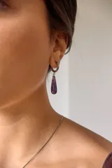 Aros colgantes de acero quirúrgico hipoalergénico con dije de piedra natural en forma de gota color azul oscuro.