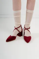 Zapato de tacón bajo color negro, con punta fina y tiras cruzadas sobre el empeine.