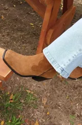Bota texana de cuero color beige, con caña media, puntera marcada y taco de madera.