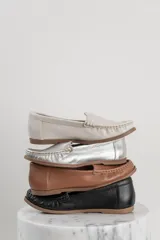 Mocasines de cuero color marrón claro con costuras a la vista.