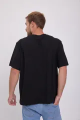 Camiseta negra de manga corta con cuello redondo y estampado amarillo con la frase "I'll Be Back" y un sol con cara.