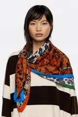 Pañuelo cuadrado de poliéster reciclado con diseño de patchwork que combina diferentes estampados animales como leopardo y serpiente. Presenta bordes en contraste de colores negro, rojo y verde.