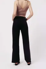 Pantalón de jean negro de corte wide leg con apliques de strass plateados.