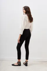Pantalón negro de corte recto, con paneles de cuero sintético en los laterales y rodillas acolchadas.