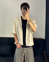 Camisa beige de corte boxy fit, manga corta y confeccionada en lino viscosa.