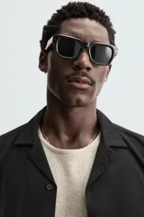 Camisa de calce relajado confeccionada en tejido fluido de mezcla de viscosa, color blanco. Presenta cuello bowling, manga corta, aberturas laterales en el bajo y cierre frontal con botones al tono.