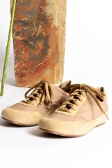 Zapatillas deportivas color crema con detalles en gamuza beige.