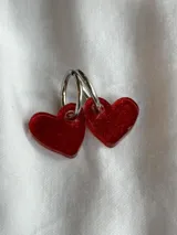 Aros colgantes con forma de corazón, hechos de acrílico negro y con cierre de aro plateado.