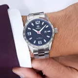 Reloj Marea modelo B3618902 de caballero, con movimiento japonés de 3 agujas y calendario. Caja de acero de 44mm con bisel rojo, brazalete de acero y esfera azul oscuro con segundero rojo. Resistente al agua hasta 10 ATM.