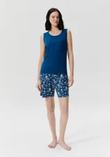 Conjunto de pijama azul con estampado de flores blancas, compuesto por musculosa con bolsillo en el pecho y short con cintura elástica.