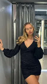 Minivestido negro de lurex con escote en V, mangas largas abullonadas y corte ajustado.