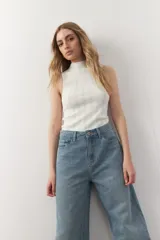 Musculosa negra de tejido de punto acanalado, con cuello alto y corte ajustado.