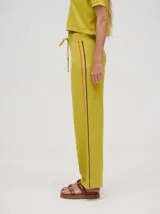 Pantalón negro de algodón, corte holgado y pierna ancha con pretina elástica. Presenta rayas blancas y celestes a los costados.