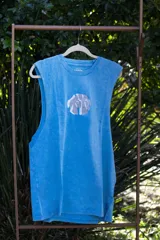 Musculosa celeste con efecto gastado y estampado circular en el pecho con diseño abstracto en tonos grises.