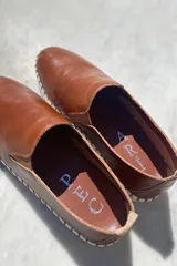 Slippers de cuero celeste con elásticos laterales y suela de goma blanca.