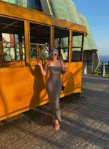 Vestido midi negro con estampado de lunares blancos, breteles finos y corte ajustado.