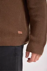 Sweater verde oscuro de punto con cuello alto y cierre de cremallera parcial. Tejido de canalé vertical.