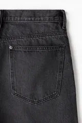 Bermuda de denim color gris oscuro, corte holgado, tiro caído, cinco bolsillos y cierre frontal con botón.