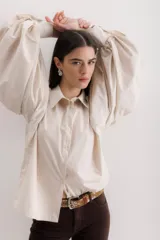 Camisa color beige de algodón con mangas abullonadas y cierre con botones.